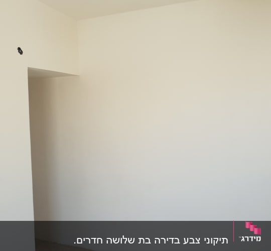 קיר צבוע בלבן עם חור קטן בפינה